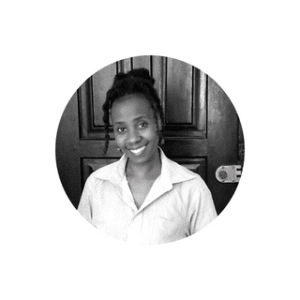 a black and white picture of the blog author standing infront of an entrance door to one of her interior design projects.
